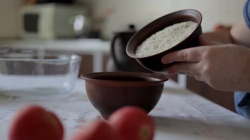 Hands Preparing a Bowl of Rice in Kitchen