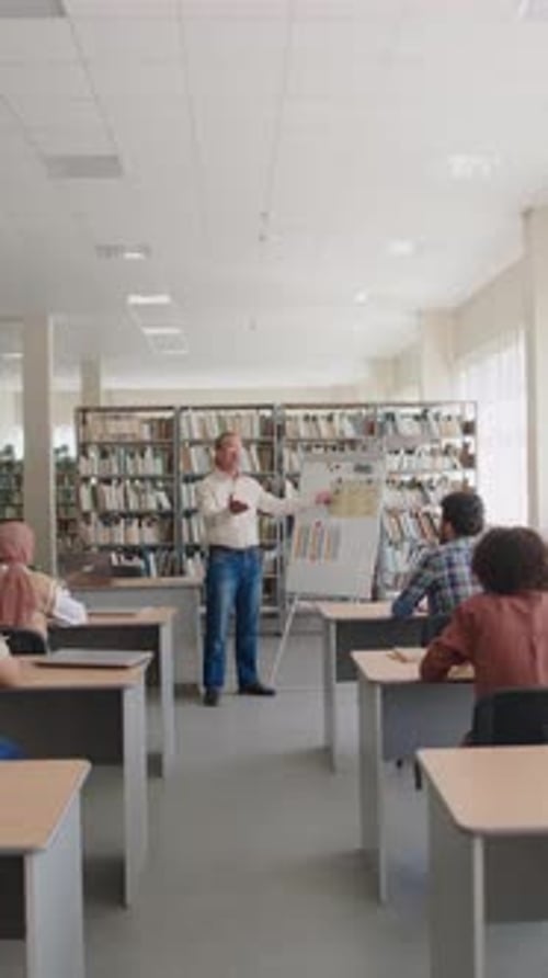 Teacher Explaining English Grammar on Flipchart to Students