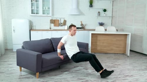 Man Doing Tricep Dips on Couch Indoors