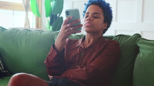 Junge Afroamerikanerin mit Handy hört und zeichnet Sprachnachrichten auf