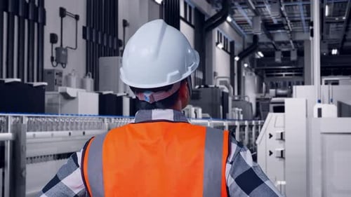 Close Up Back View Of A Male Engineer Looking Around While Arms Akimbo In Bottling Factory