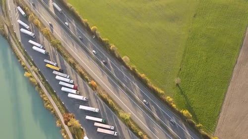 Top Down Aerial View of Highway Interstate Road with Fast Moving Traffic and Parking Lot with Parked