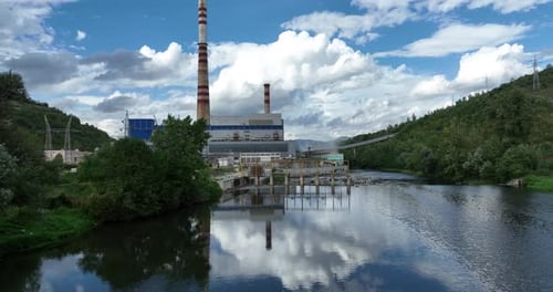 Aerial Drone Shot of Coal Power Plant with Two High Cooling Towers Next to Blue River