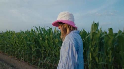 Young Woman Walk in Front of a Cornfield