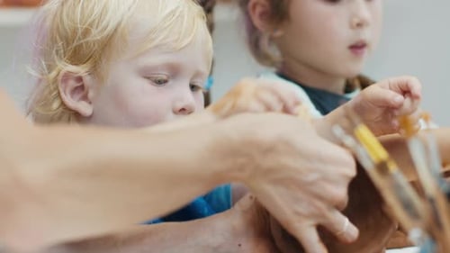 Children Painting Pottery Together in an Art Studio