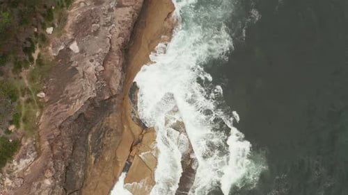 Waves Crashing on Rocky Shore from Above