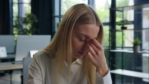 Woman Experiencing Stress and Headache at Workplace
