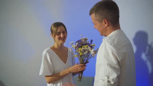 Woman Receives Flowers From Man and Kisses Him