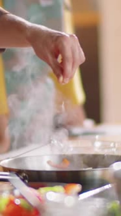 Close-up of Unrecognizable Hand Sprinkling Salt During Cooking Master Class
