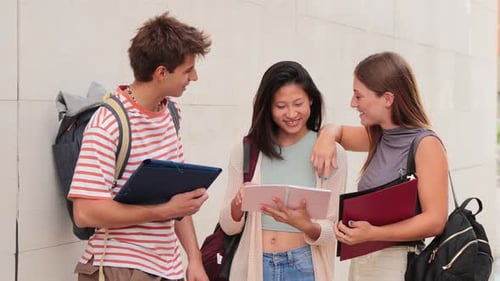 One Man and Two Teenage Women Talking About the Lesson Standing at University Campus Group of
