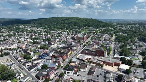 American City with houses, tower, blocks and main street in Summer. Traffic scene on junction at sun