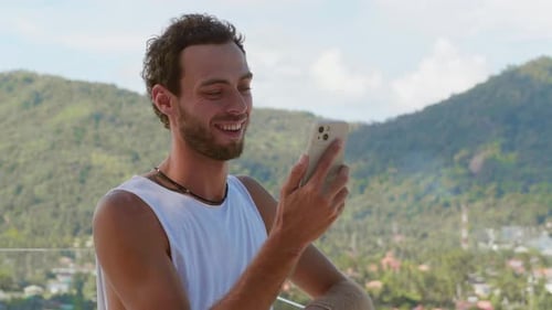 Portrait of Smiling and Happy Bearded Caucasian Man Standing on the Balcony Overlooking Beautiful