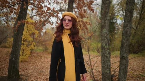Elegant Lady Adjusting Hair in Autumn Woods