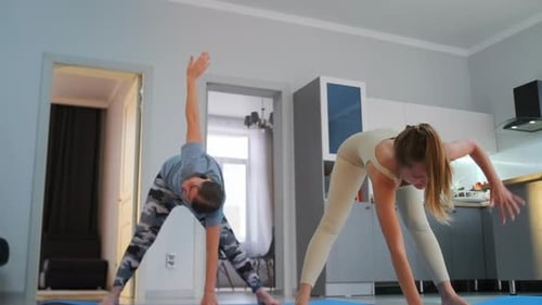 Pratique du yoga à domicile en mettant l'accent sur le bras levé à Trikonasana