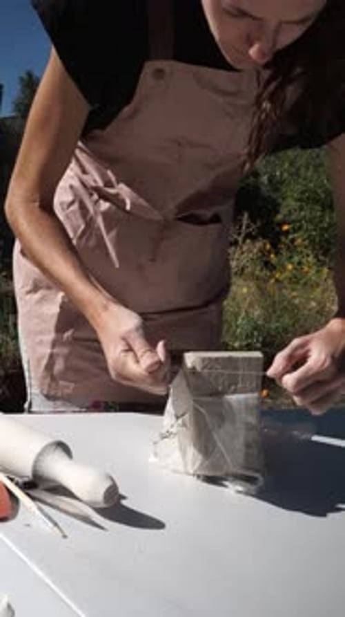 Woman Cutting Clay Outdoors on Sunny Day