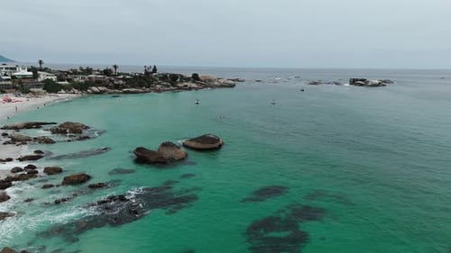 Drone clip of boats in calm turquoise ocean water near the beach