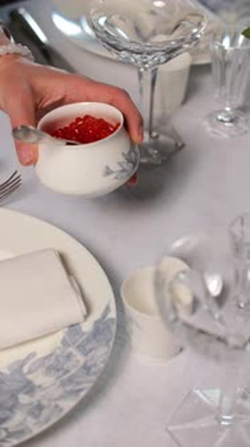 Placing Small Bowl with Red Caviar on Elegant Table Setting