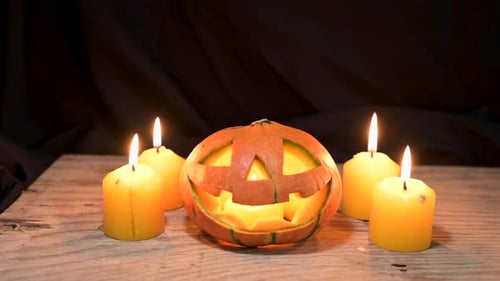 Halloween-Kürbis mit Kerzen Licht auf Holz im dunklen Raumhintergrund