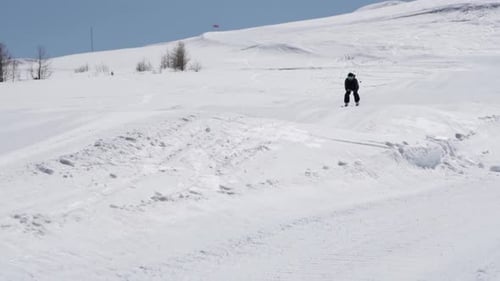 Skier Gliding Down a Snowy Mountain in Winter