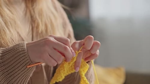 Woman Crocheting Yellow Yarn at Home