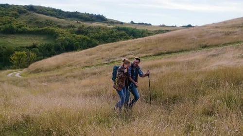 Couple Hiking on Hill with Hiking Poles