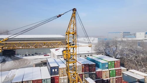 Versandcontainer und Frachtkran auf dem Lagerplatz im Winter, Luftaufnahme