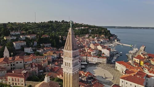 Historic seaside town with harbor. Archangel Michael statue on church.