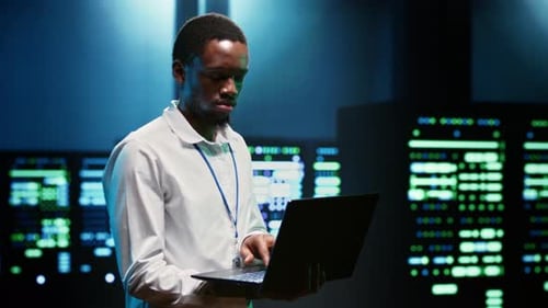 Afroamerikanischer Programmierer inspiziert Servercluster im Rechenzentrum