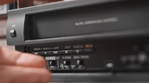 Pulls Out VHS Tape Cassette From a Vintage VCR Recorder