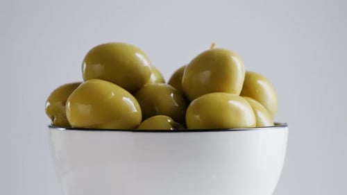 Large Juicy Andalusian Green Olives with Pits Rotate on a White Background Made in Spain