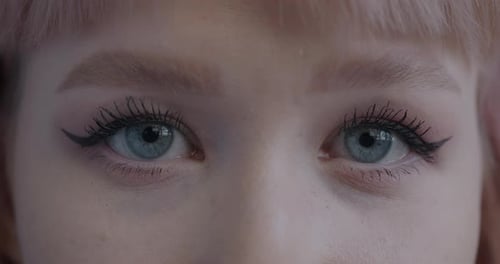 Closeup Portrait of Young Woman's Eyes with Stylish Makeup Looking at Camera Blinking