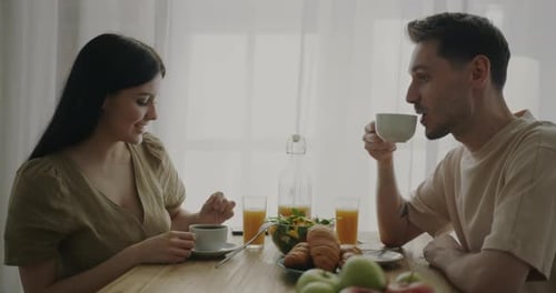 Happy Couple Eating Breakfast Together At Home