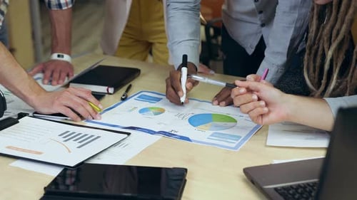 Close view of business people which working financial diagrams during creating joint project in cont