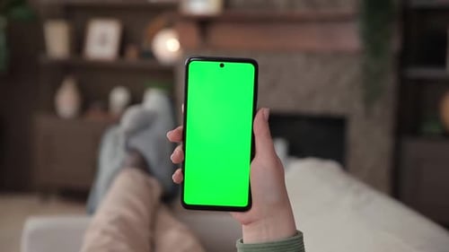 Point of View of Woman Lying on Couch Using Smartphone with Chroma Key Green Screen Chromakey Mock