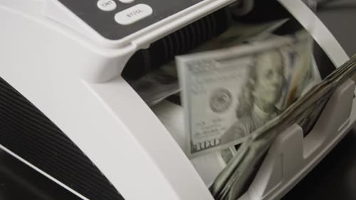 Money Counter Machine Counting Stacks of United States Dollars