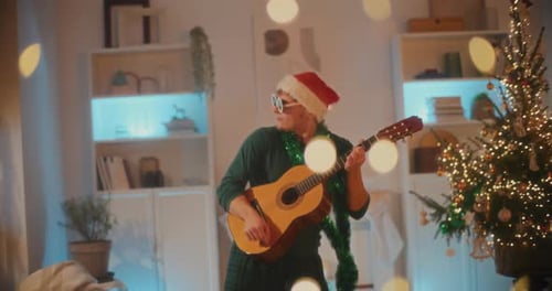 Young Adult Plays Guitar at Christmas Celebration