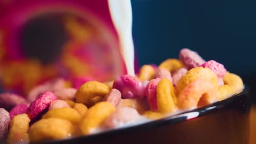 Colorful Cereal and Milk Being Poured into Bowl