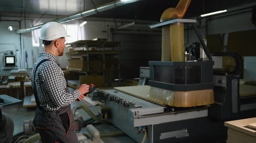 Operator Using CNC Router to Cut Wooden Panel