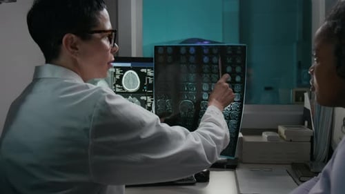 Doctor Demonstrating Brain Tomography Results on Film to Patient in Clinic