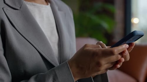 Woman in Blazer Using Smartphone in Office