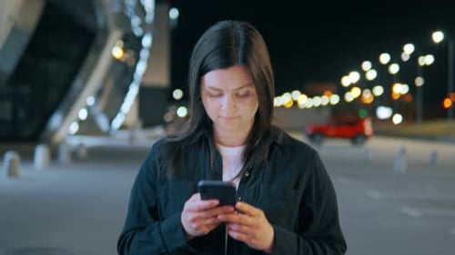 Fille avec un téléphone dans ses mains sur fond de lumières bokeh