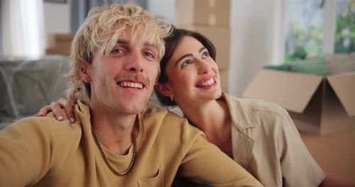 Happy Couple Smiling in New Home with Boxes