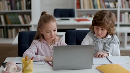 Konzentrierte Grundschüler lösen Prüfungsaufgabe am Laptop Junge und Mädchen im Teenageralter denken über die richtige Antwort nach