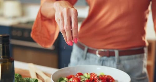 Adding Spices to a Colorful Salad