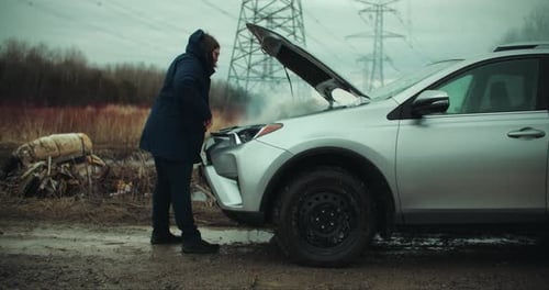 Frustrated Woman Inspecting Smoke Coming out of Broken Car Engine. Vehicle Breakdown Road Side Accid