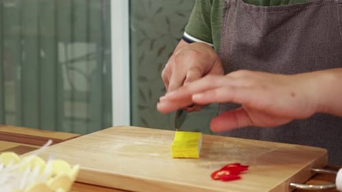Closeup View of Male Hands Sitting at the Table and Cutting Tofu Cheese Into Cubes By Sharp Knife