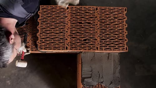 Construction Worker Building a Wall with Red Bricks