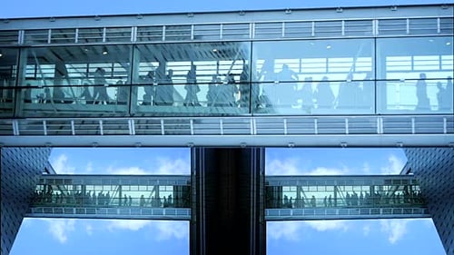 People Walking in Glass Urban Skyway
