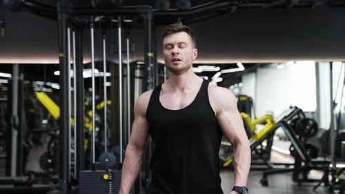Muscular Man Walking Confidently in Gym Setting