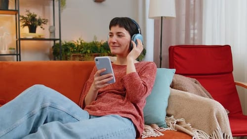 Woman Relaxing on Couch Listening to Music